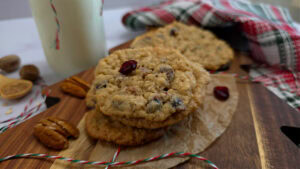 Southern Style Oatmeal Cranberry Pecan Cookies for Christmas Baking on a holiday cutting board with milk