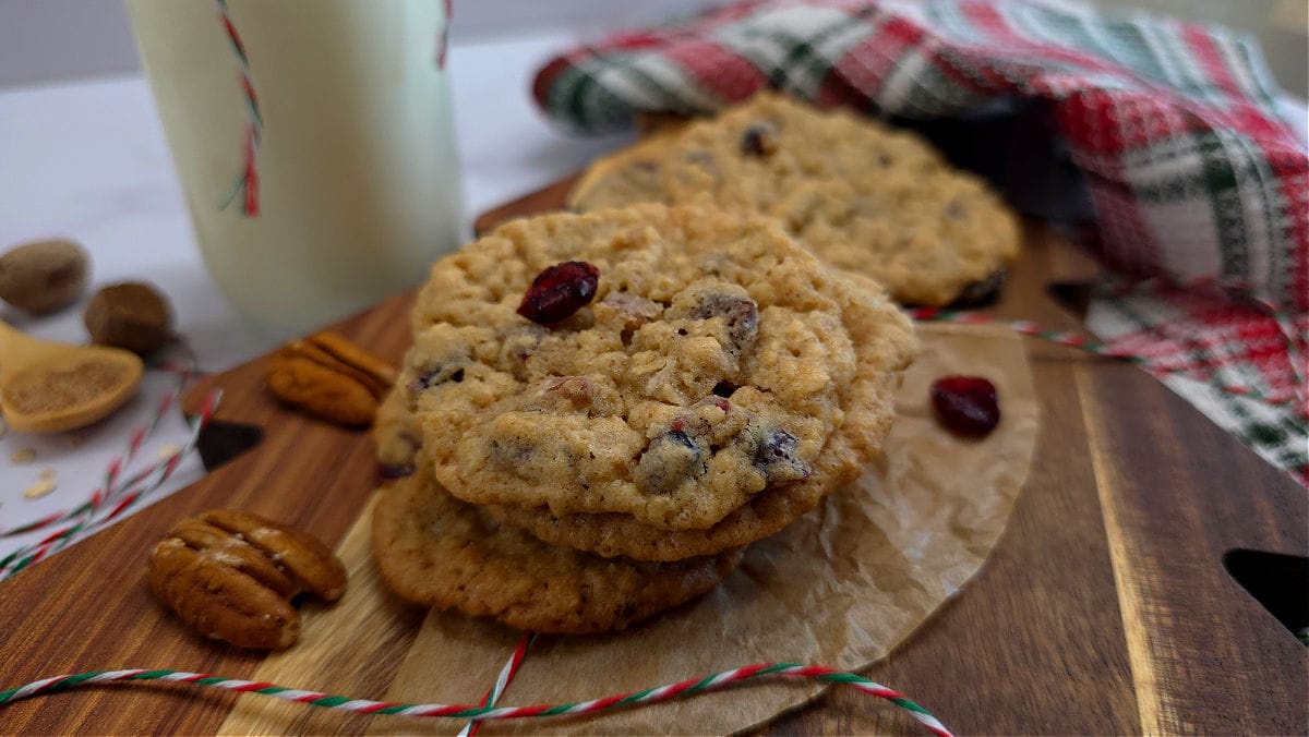 Southern Style Oatmeal Cranberry Pecan Cookies for Christmas Baking on a holiday cutting board with milk