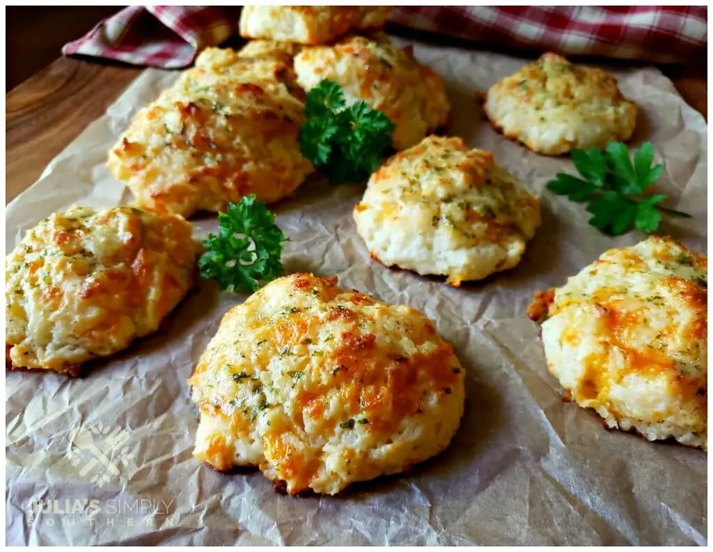 Freshly baked cheese biscuits arranged on a sheet of parchment paper