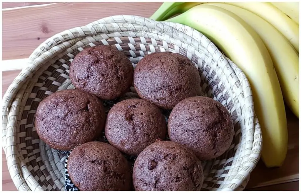 basket with chocolate banana muffins next to a bunch of fresh bananas