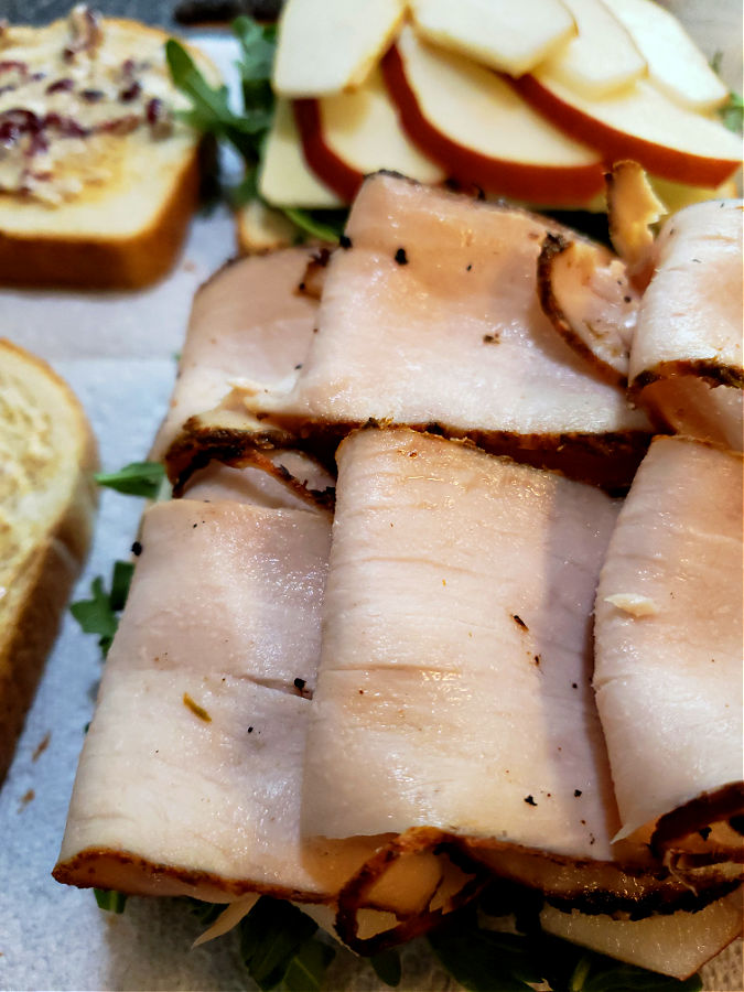 Layering blackened slices of turkey on sandwiches