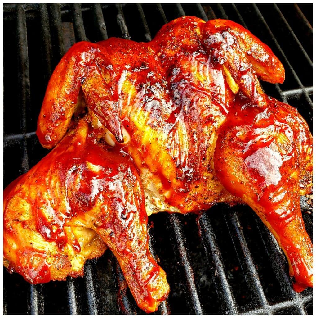 A butterflied chicken cooked on a gas grill and finished with a sweet spicy barbecue sauce