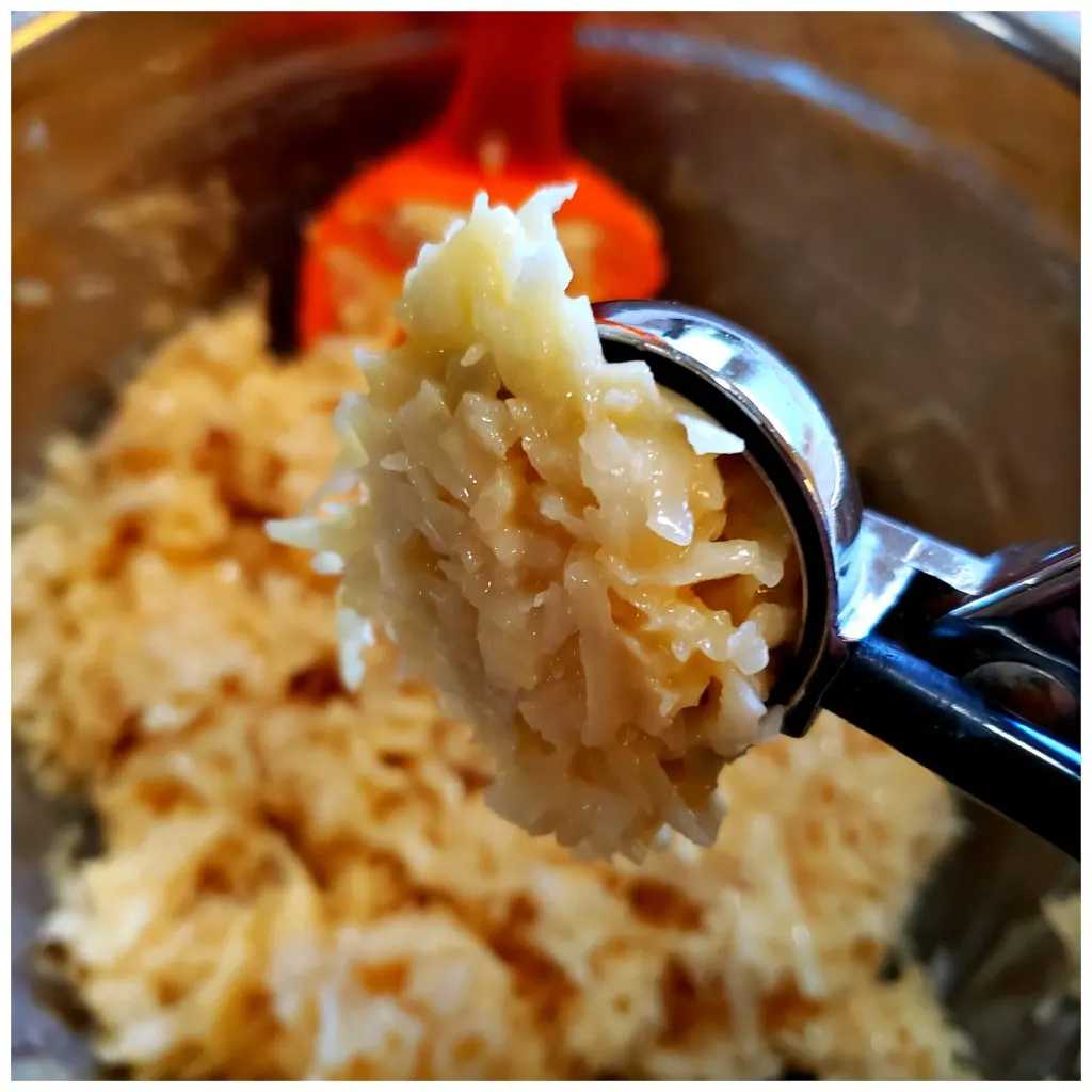 Using a 1 inch scoop to portion out macaroon cookies for baking