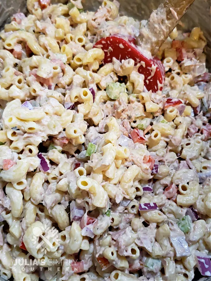 mixing the tuna macaroni salad with the creamy dressing