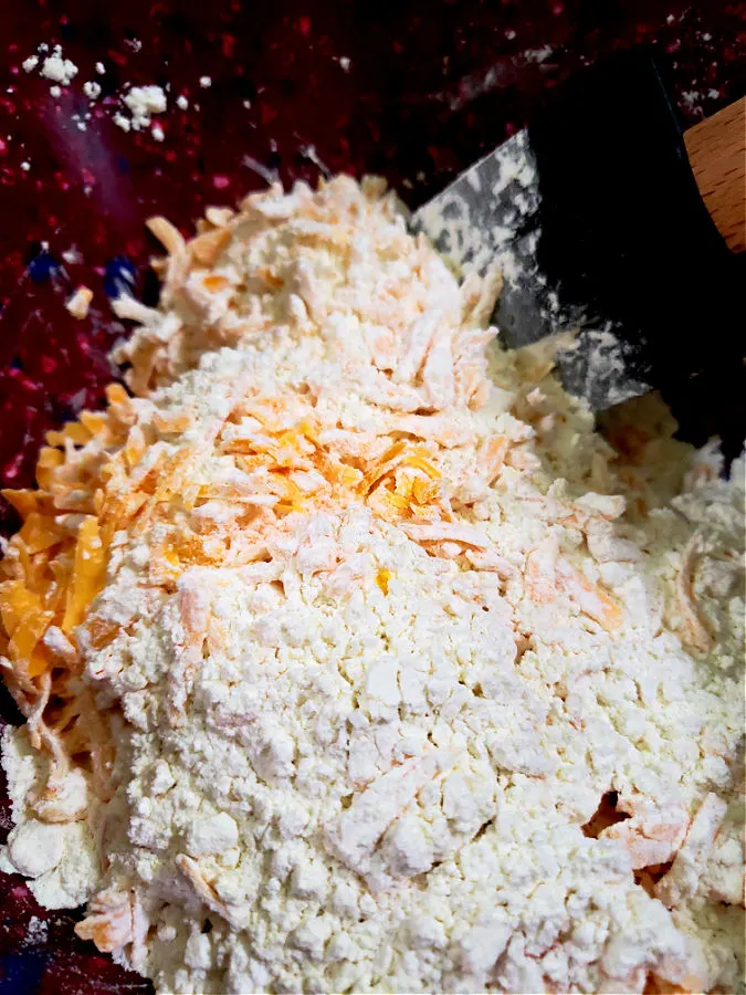 Grated cheddar cheese in a bowl with self rising flour