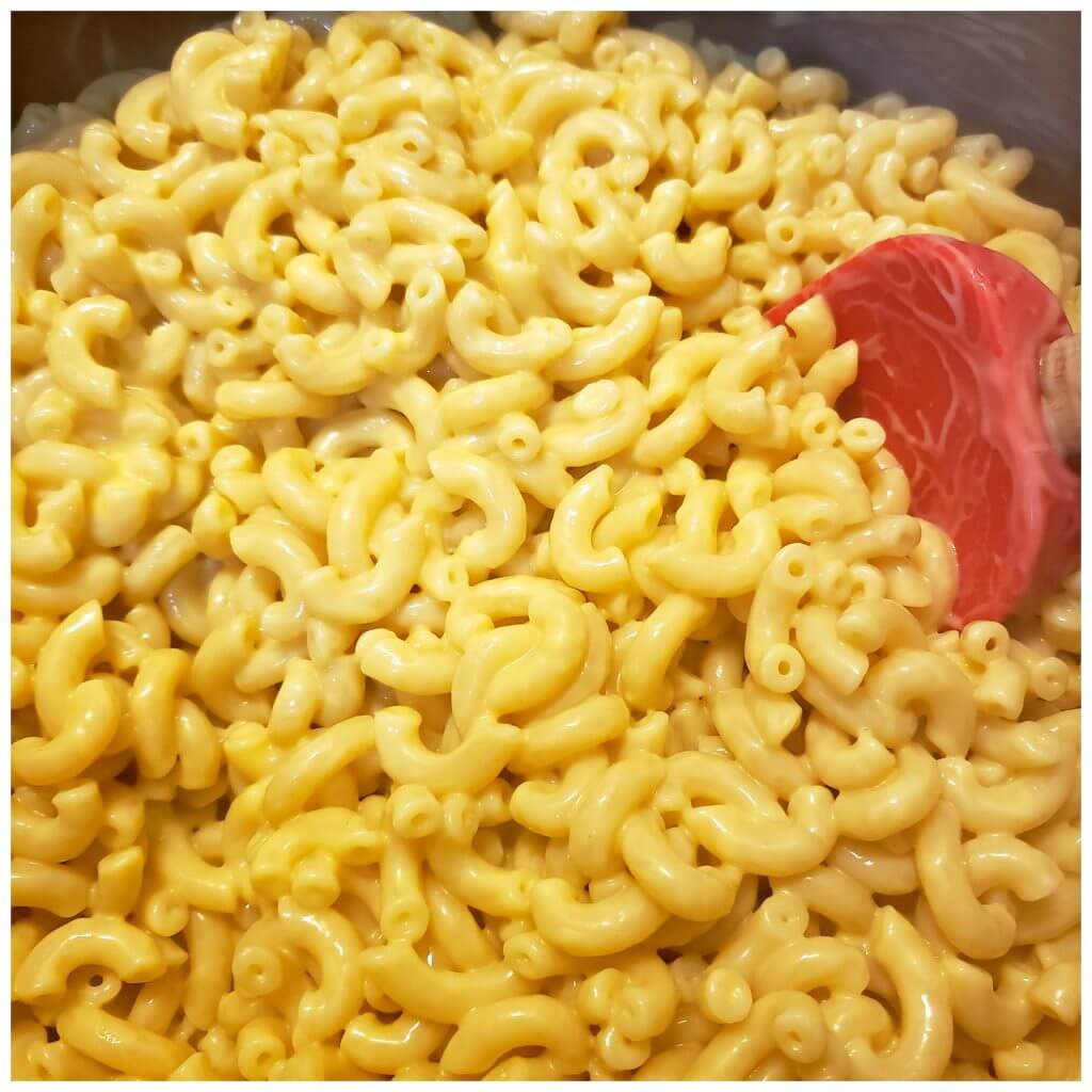combining elbow macaroni pasta with cheese sauce