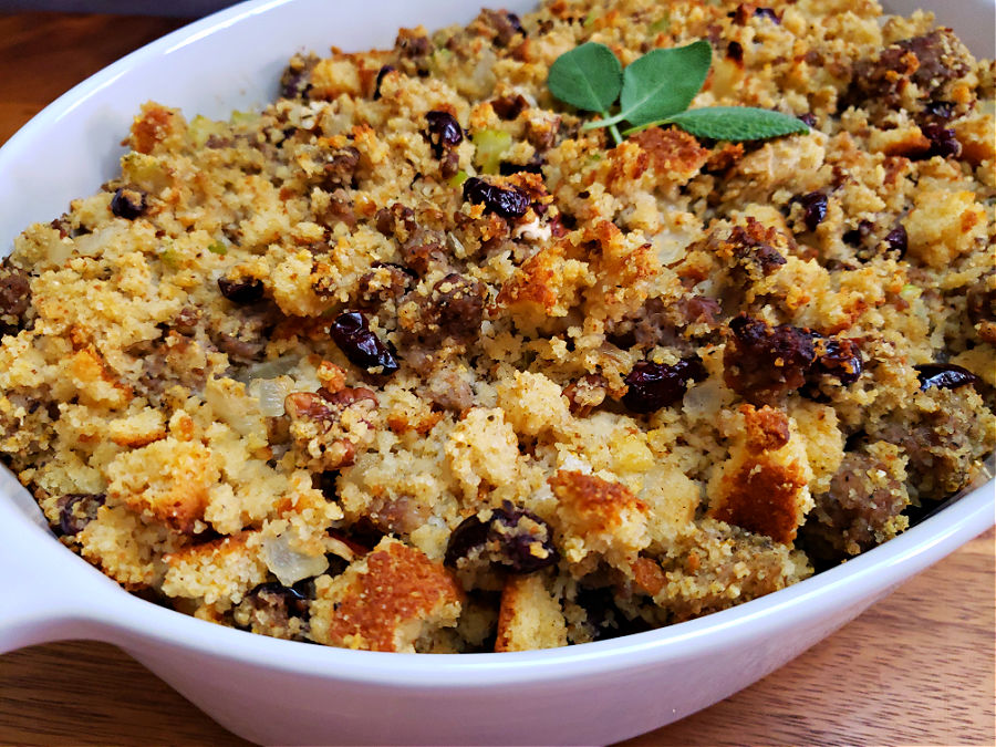 Baking dish with holiday stuffing made from cornbread, sausage, sage, cranberries, and pecans