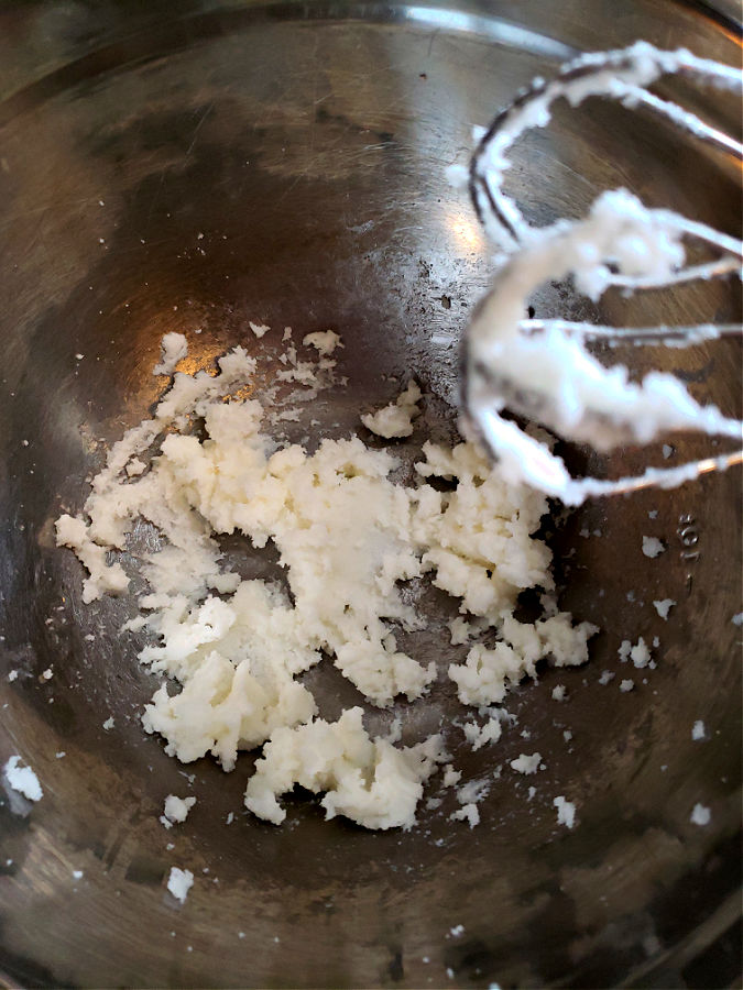 creaming vegetable shortening with sugar in a mixing bowl