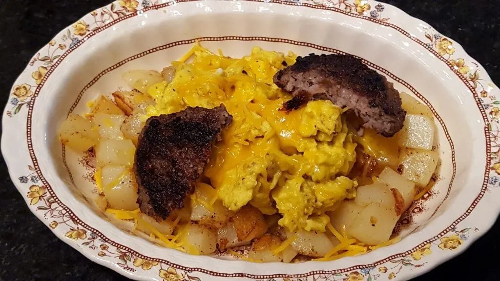 Breakfast bowl meal with potatoes, sausage, eggs and cheese