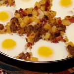 Large skillet with country breakfast hash with eggs