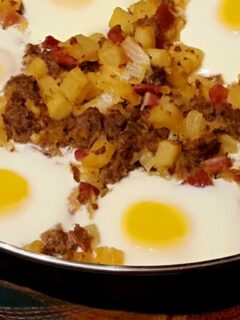 Large skillet with country breakfast hash with eggs