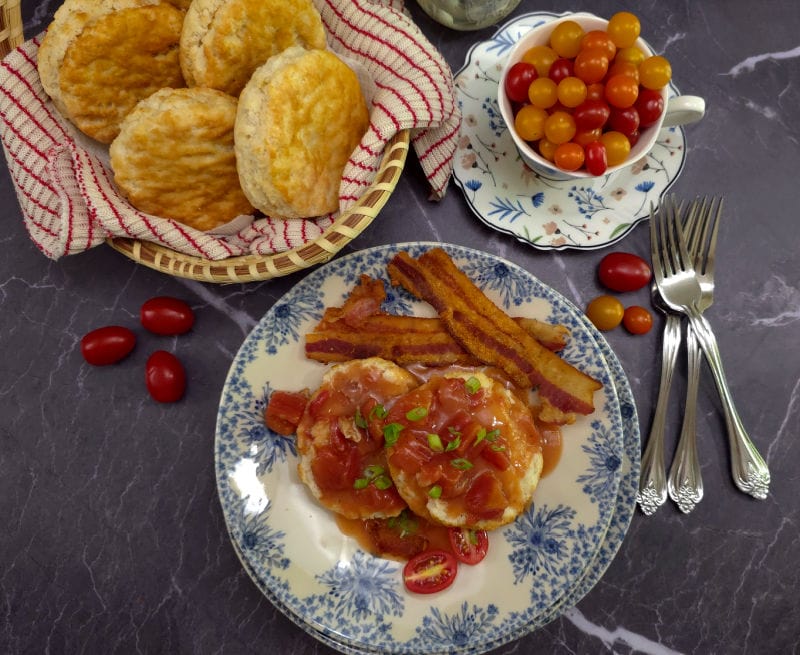 Breakfast plate served with bacon, biscuits topped with Southern Tomato Gravy