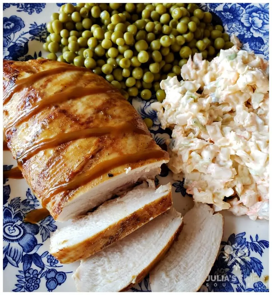 Easy Grilled Carolina Gold Barbecued Chicken Breast on a blue and white plate served with peas and slaw