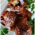 Tender baked pork country style ribs with barbecue sauce glaze on a white rectangle platter