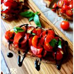 Recipe for Bruschetta made with tomatoes from the garden, herbs and garlic on toasted Italian bread with a balsamic glaze drizzle