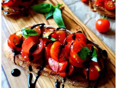Recipe for Bruschetta made with tomatoes from the garden, herbs and garlic on toasted Italian bread with a balsamic glaze drizzle