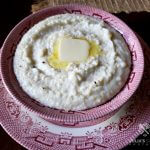 Best Southern style Grits in a red and white bowl with a pat of butter on top