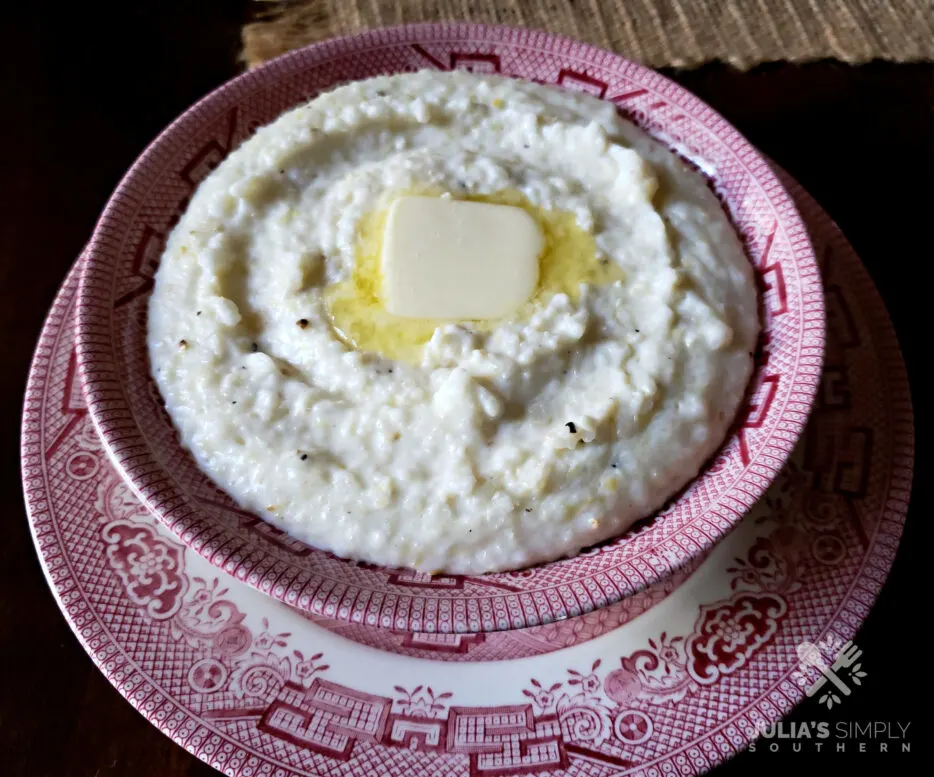 Best Southern style Grits in a red and white bowl with a pat of butter on top