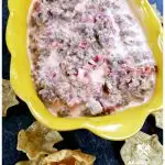 Sausage Dip recipe served in a yellow dish with corn chip scoops