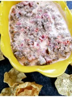 Sausage Dip recipe served in a yellow dish with corn chip scoops