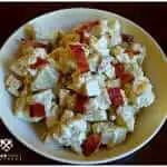 Small batch Southern style potato salad short cut version side dish with bacon in a vintage yellow and white bowl