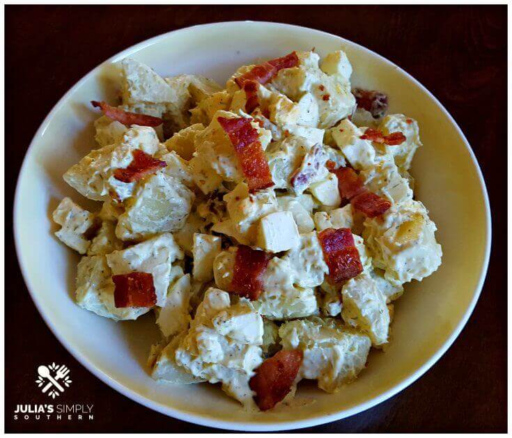 Small batch Southern style potato salad short cut version side dish with bacon in a vintage yellow and white bowl