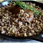 Cast Iron Skillet with Pink eyed peas and a ham hock garnished with fresh Thyme to bring luck in the new year