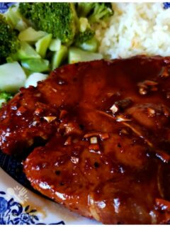 Sticky Garlic Pork Chops on a plate with broccoli and rice