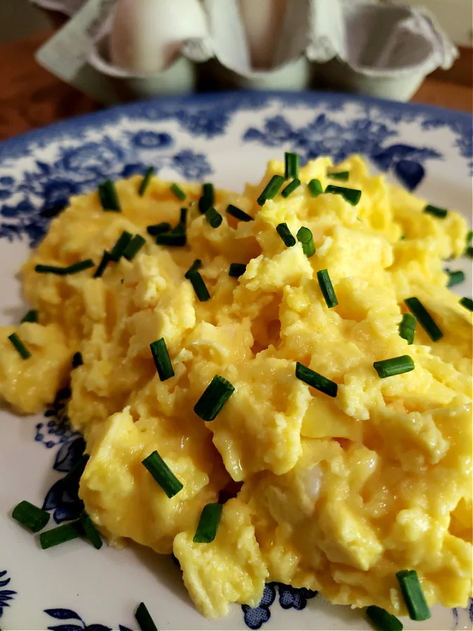 Plate with Ricotta scrambled duck eggs with fresh chives for breakfast