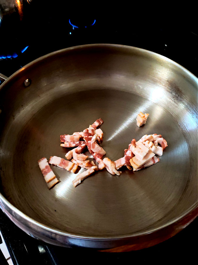 Frying bacon pieces in a stainless skillet