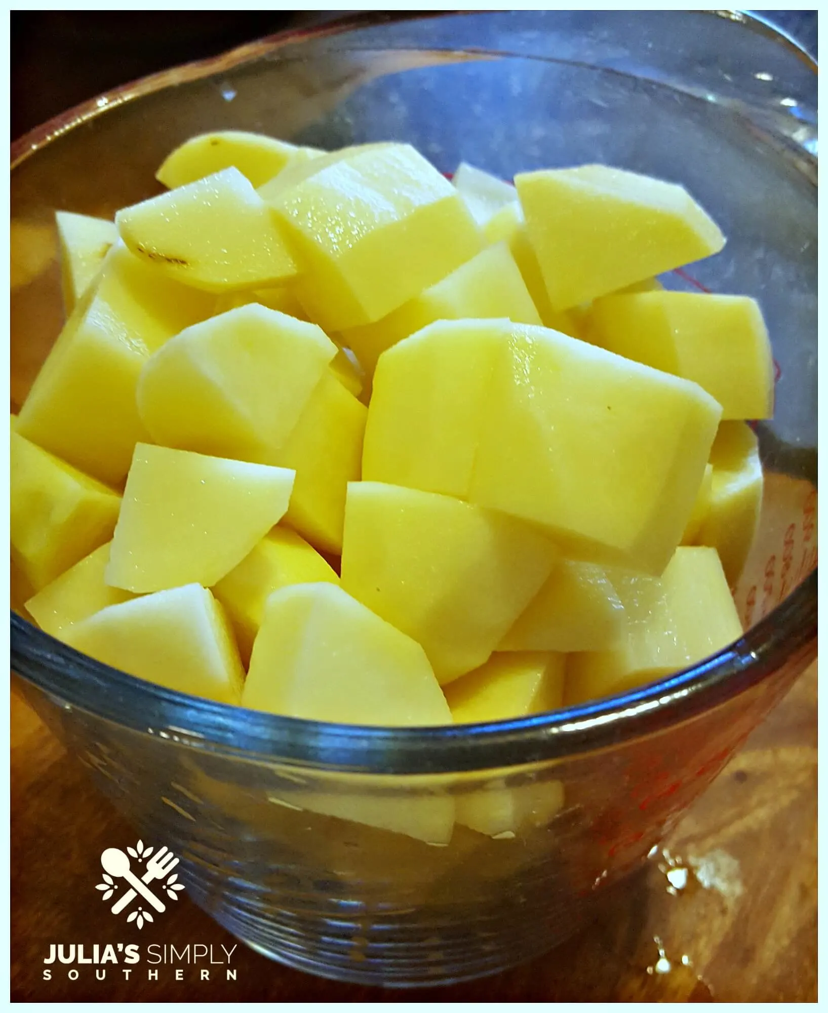Raw cubes of Russet potato for a potato salad recipe in a large glass measuring cup