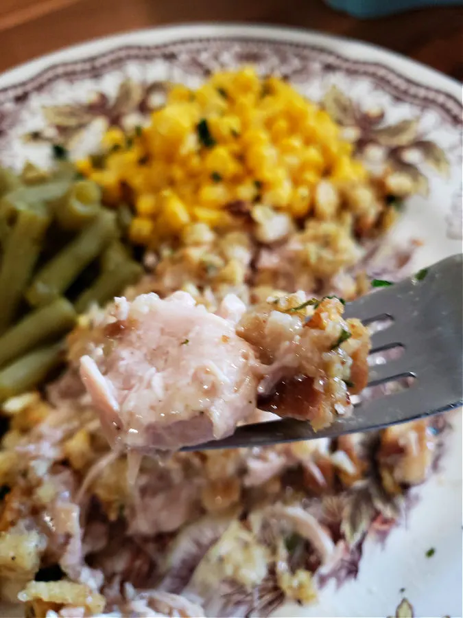fork with a bite of canned turkey stuffing casserole
