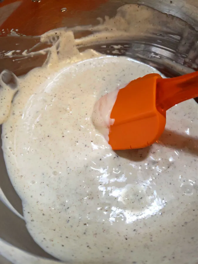 Combining the dressing in a silver mixing bowl for tuna macaroni