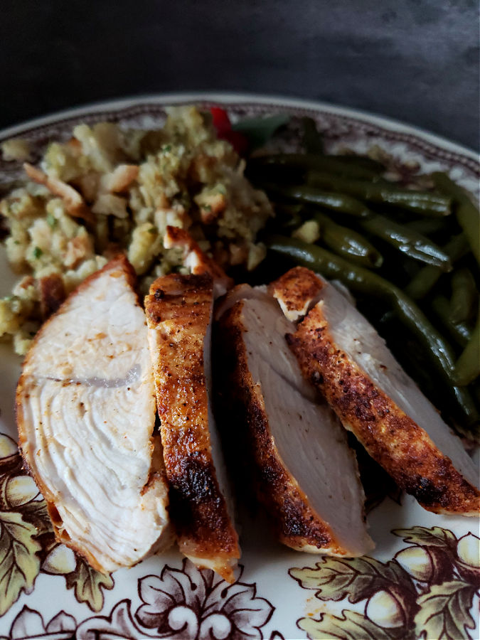 Thanksgiving plate with turkey, green beans and Southern stuffing. A delicious holiday meal.
