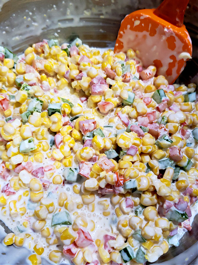 Combining the ingredients for a cold corn dip with the creamy dressing