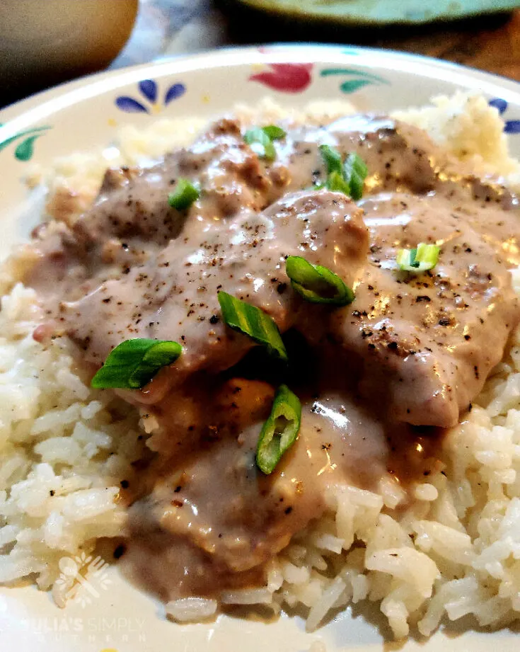 Easy Baked Cubed Beef Steaks served over rice and garnished with spring onions