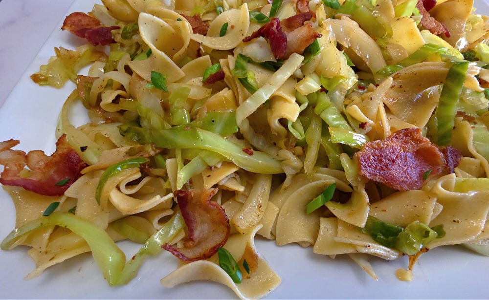 Fried Cabbage and Noodles with Bacon, garnished with thin sliced green onion