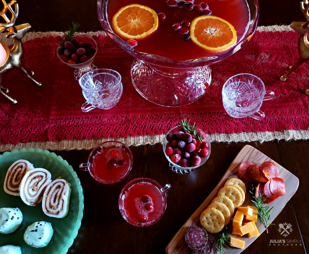 Punch bowl with Cranberry Punch being served with finger foods appetizers at a holiday party