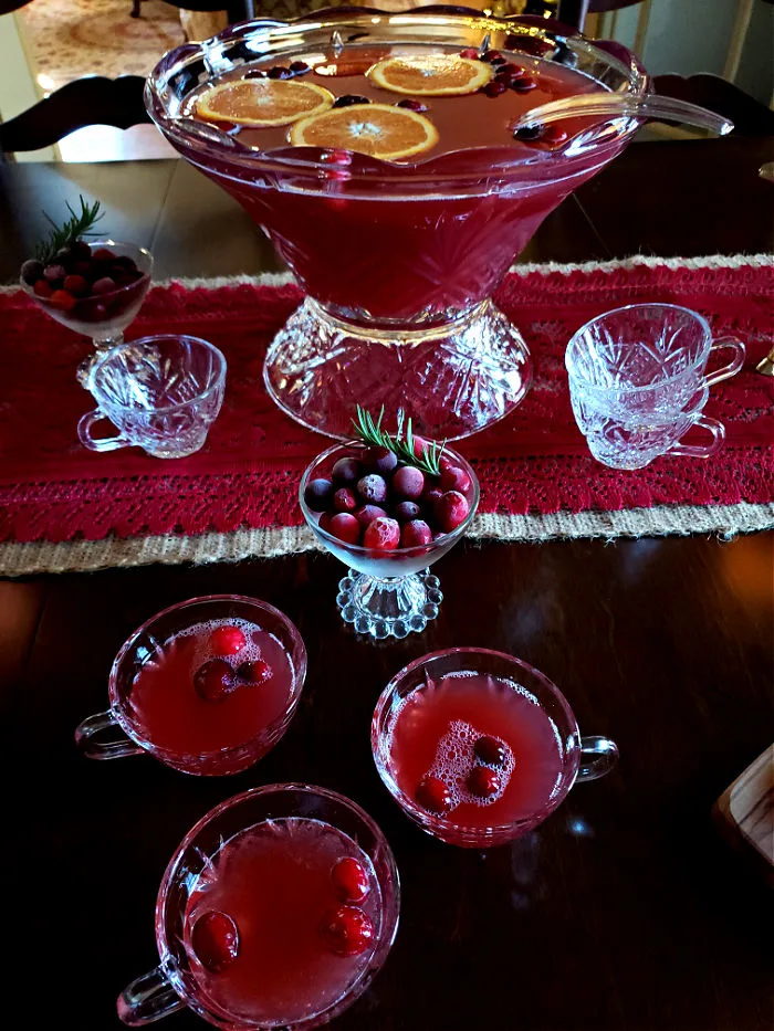 Table with punch bowl and glasses filled with Christmas Punch