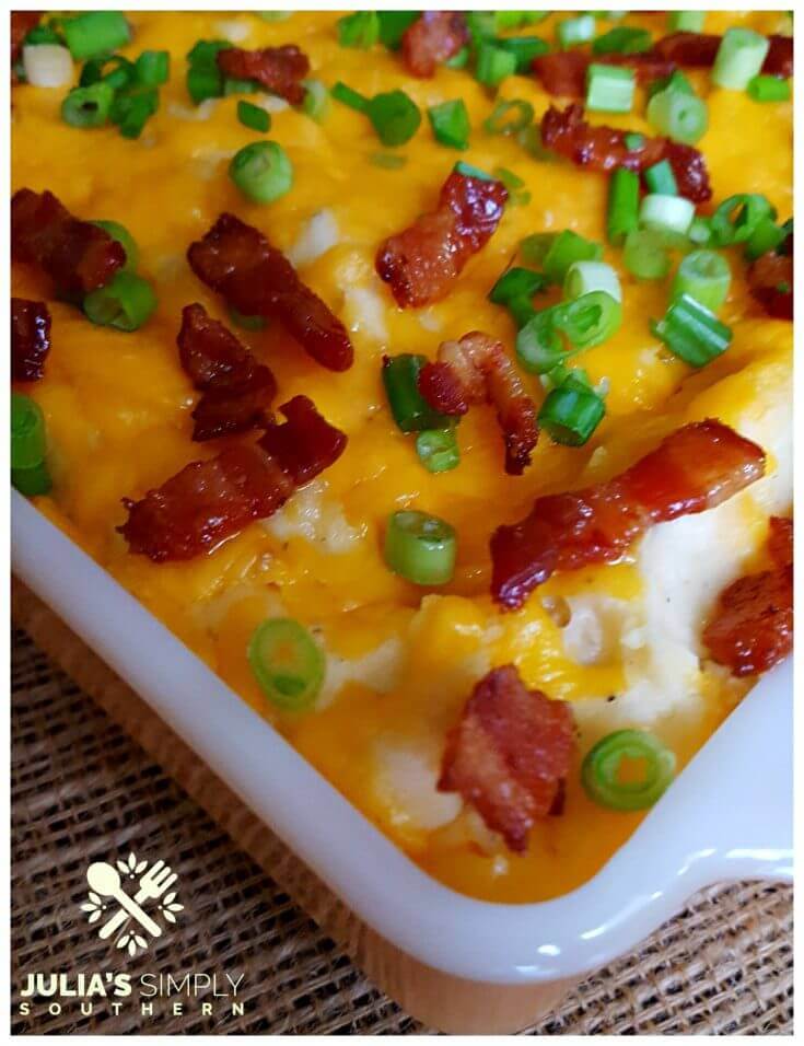 Easy Loaded Mashed Potato Casserole with cream cheese, sour cream, bacon, cheese and scallions in a vintage orange anchor hocking casserole dish