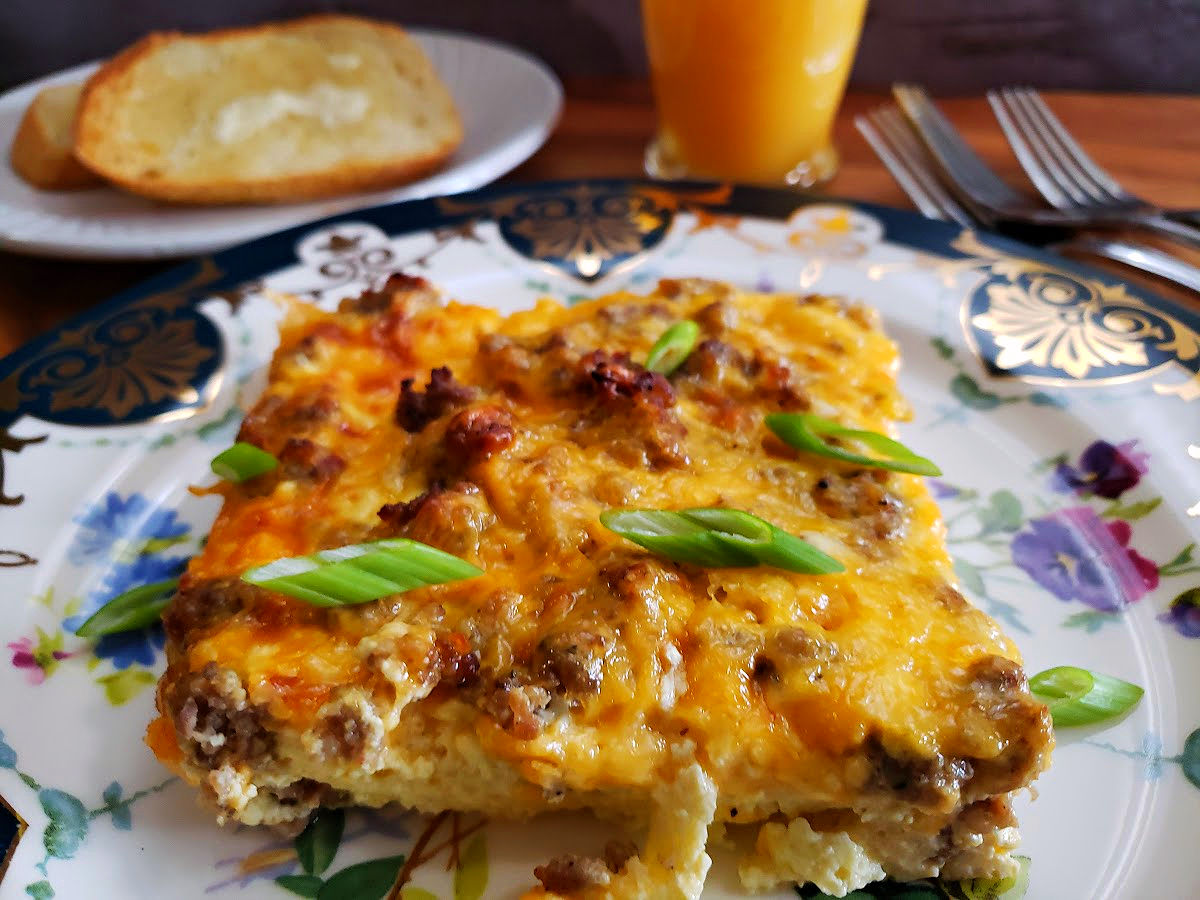 Simple breakfast casserole serving on a plate for the morning meal with orange juice and toast