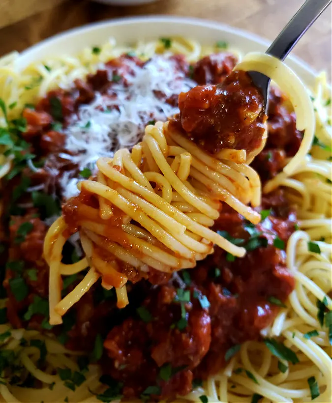 twirling spaghetti around a fork with homemade meat sauce