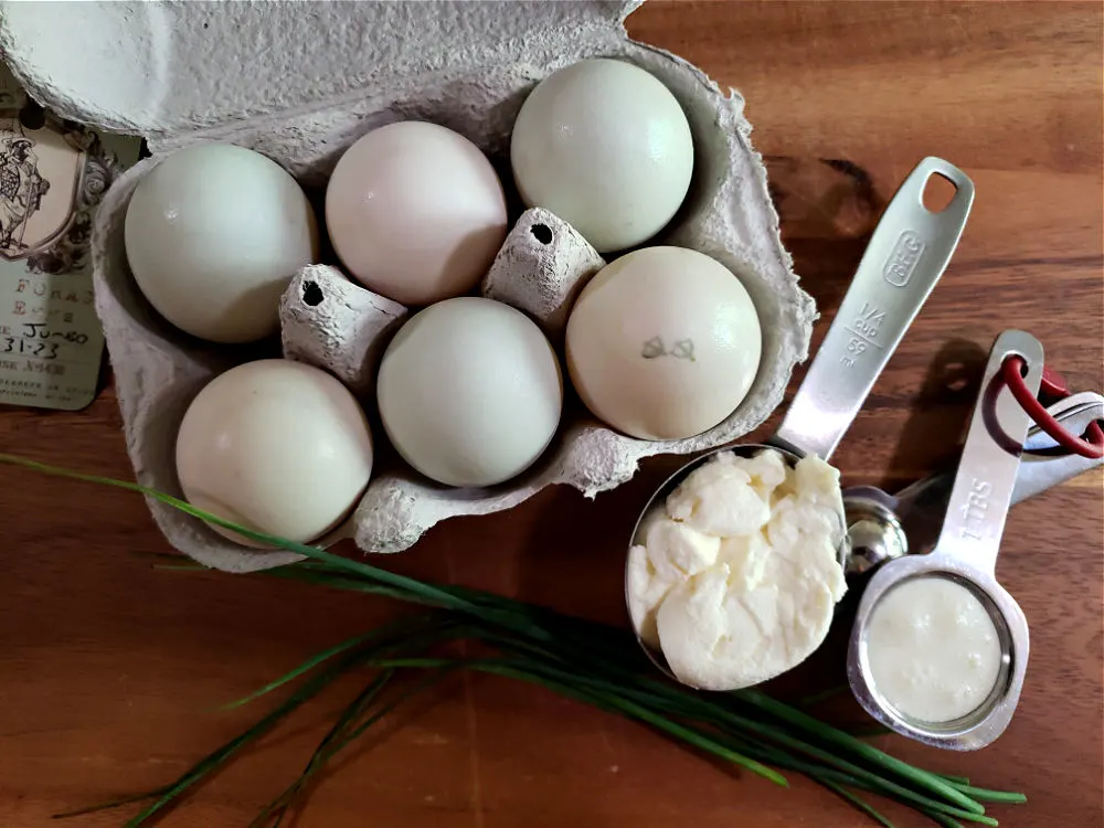 Ingredients for preparing scrambled duck eggs with ricotta cheese and fresh chives.