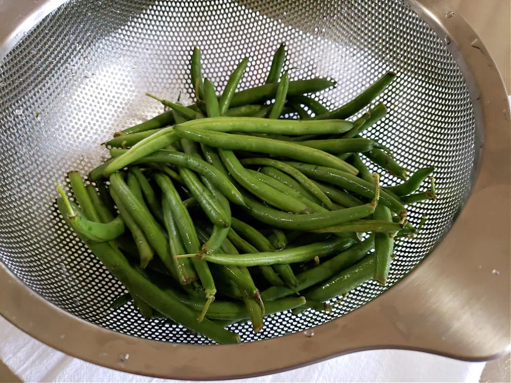 a colander with washed green beans