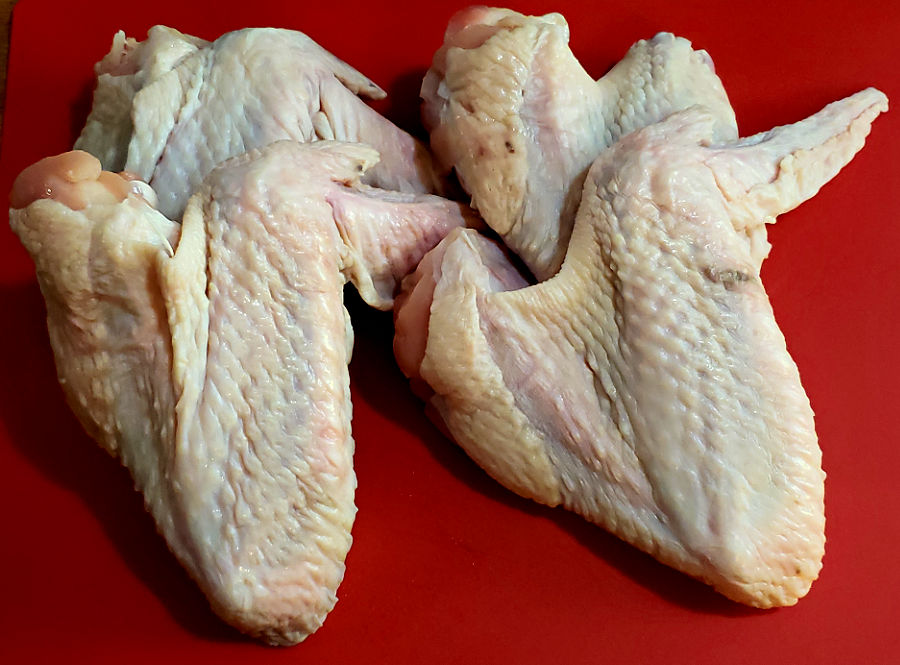 Fresh whole turkey wings on a cutting board