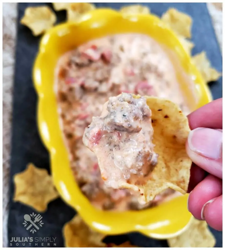Eating sausage dip appetizer on a corn scoop chip