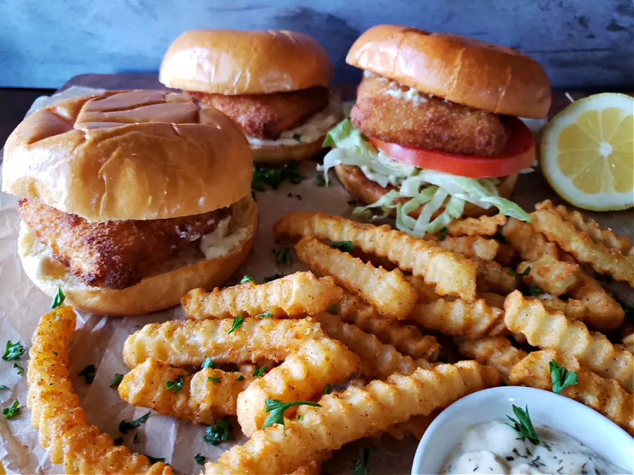 fries, tartar sauce, ketchup, lemon wedges, parsley and fish sandwiches