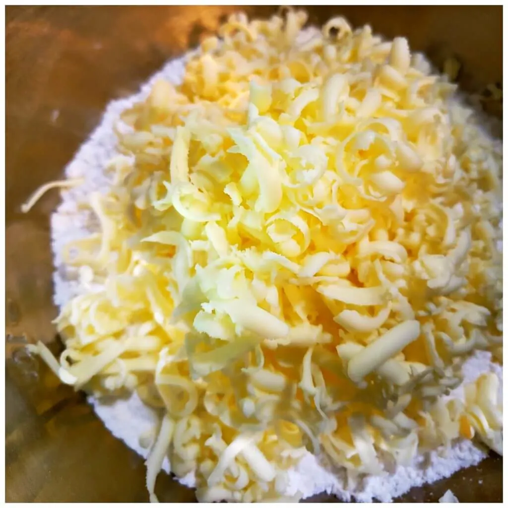 grated butter in a mixing bowl with flour
