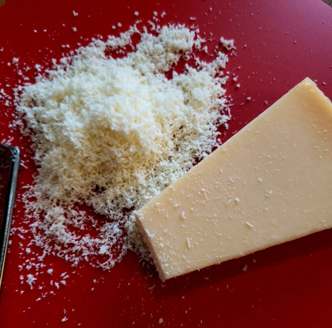 Freshly Grated Parmesan Cheese on a plastic cutting sheet
