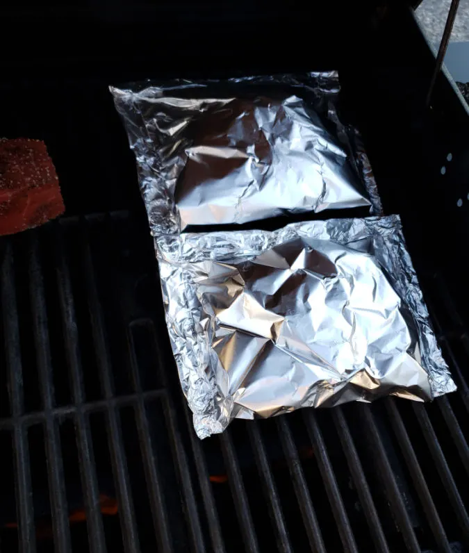 foil packets with broccoli on a gas grill cooking